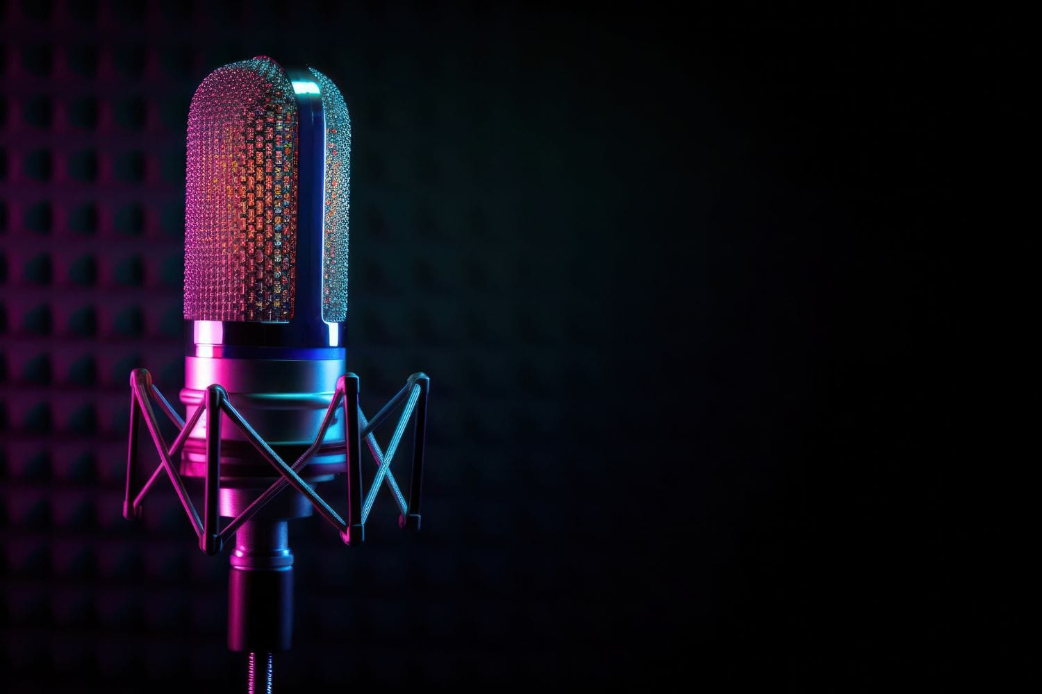 A studio condenser microphone lit in pink and teal against a dark acoustic wall